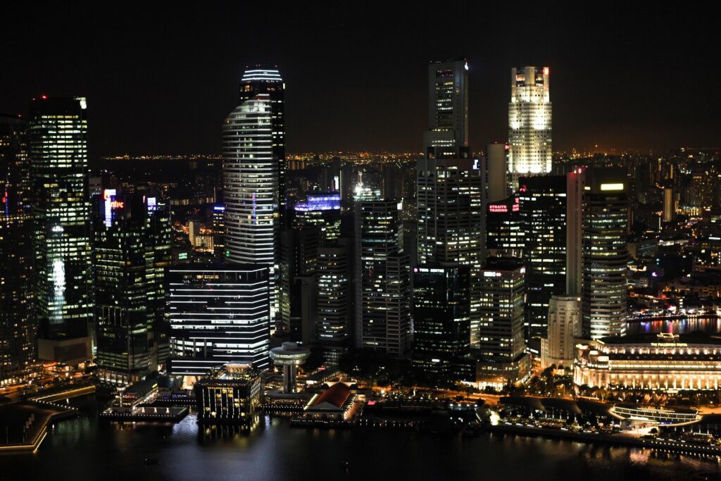 Photograph of Singapore's skyline from the perspective of the sea at night.